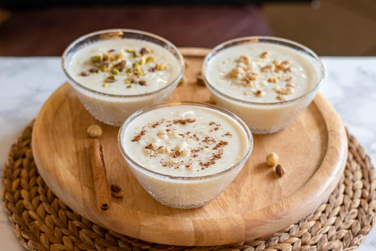 sutlac is served in 3 individual bowls and garnished with nuts and cinnamon.