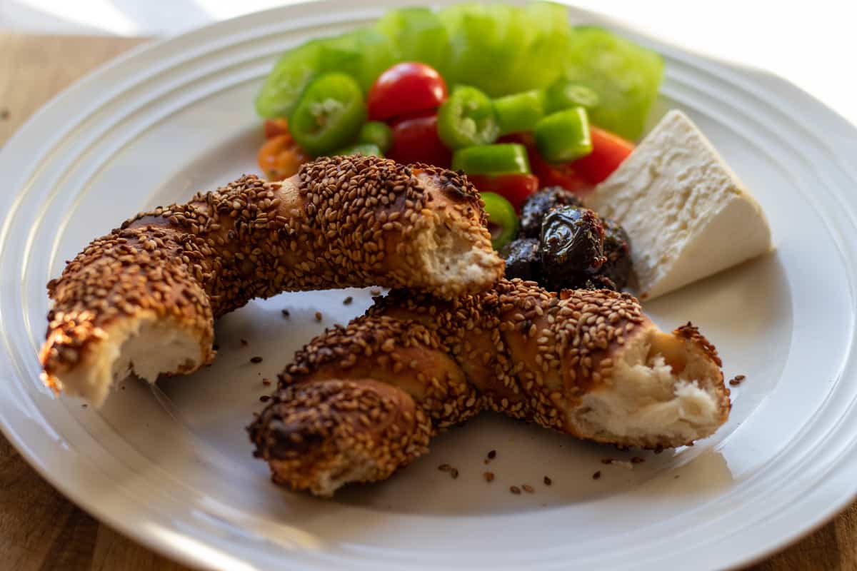 simit pieces served with few pieces of olives, feta cheese, and salad