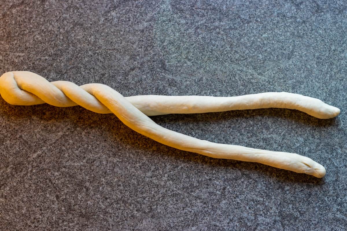 forming a braid by twisting the dough strips
