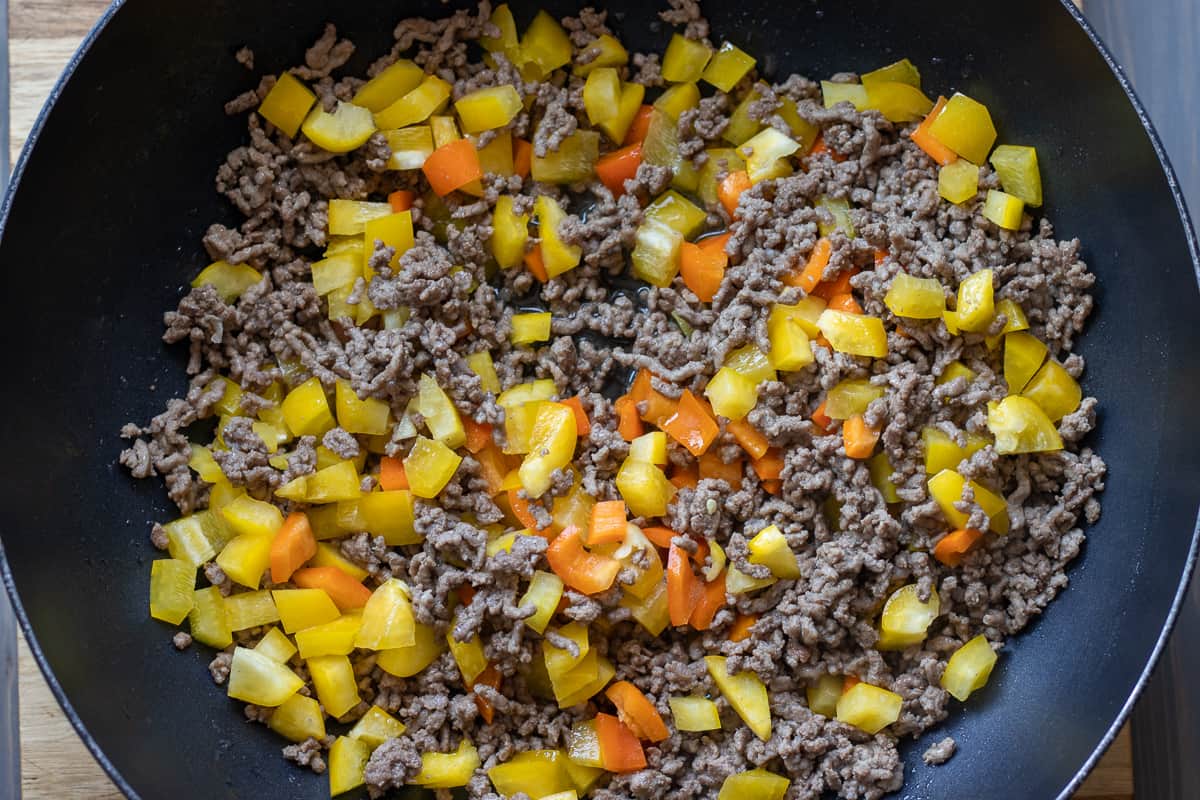 diced peppers are added to the browned beef