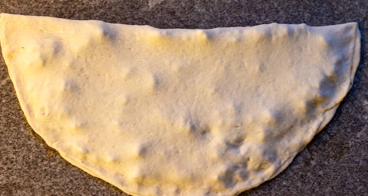 The other half of the dough is folded over the filling and the seams of the gozleme is pinched to shut.