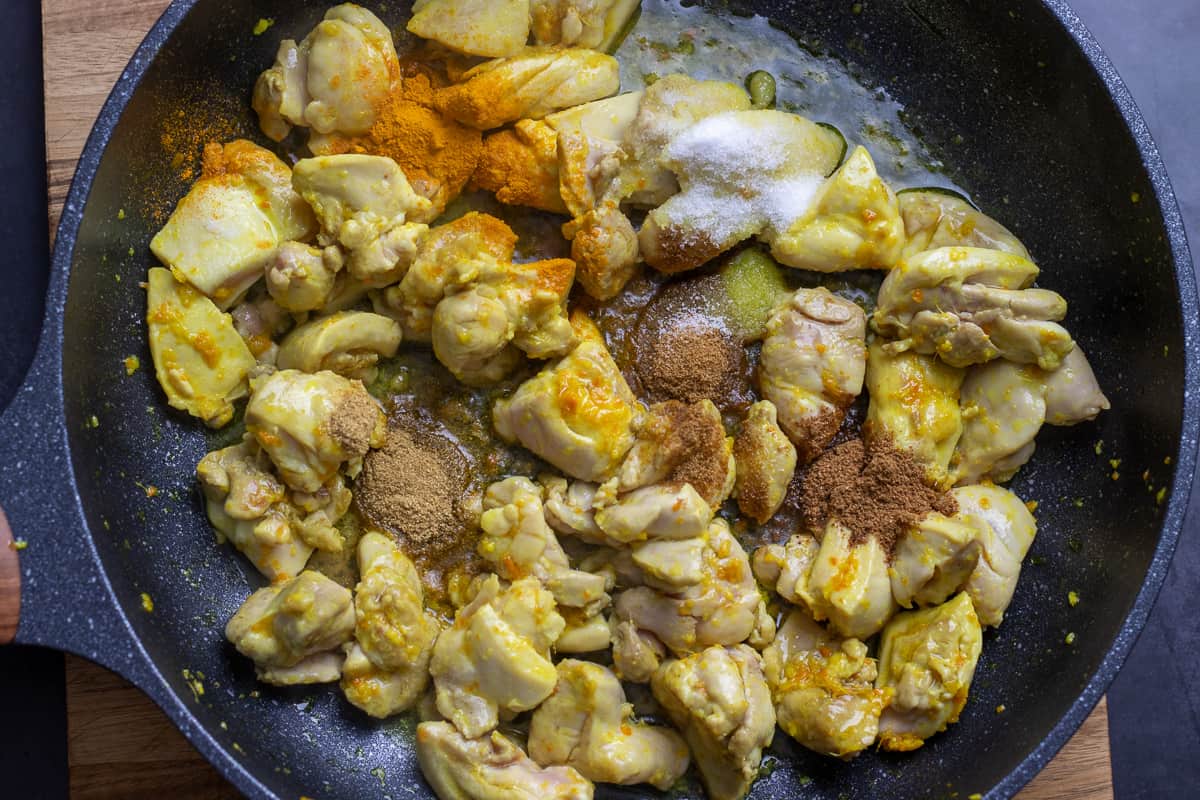 spices are added to the sautéed chicken pieces