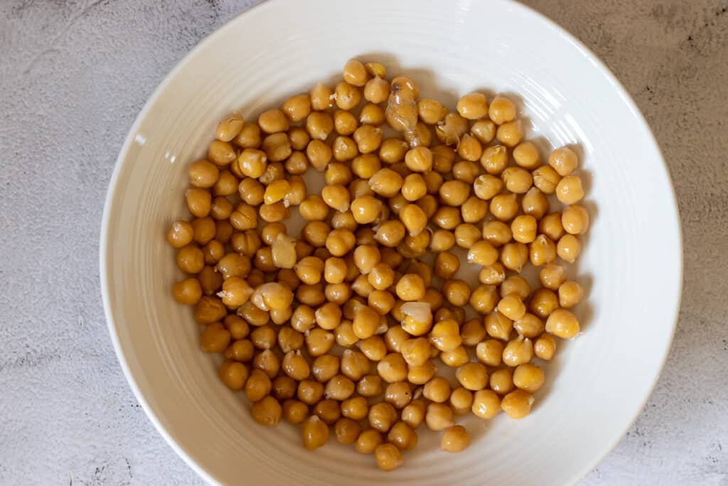 cooked chickpeas are placed in a bowl for building chicken and eggplant fatteh
