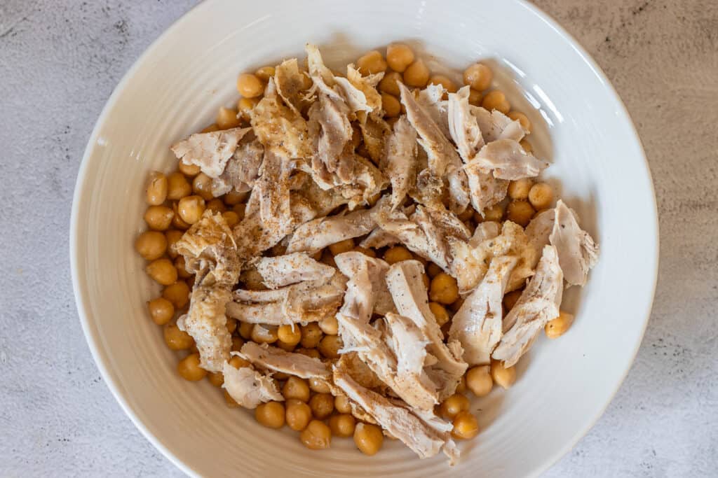 cooked chicken is placed on top of chickpeas
