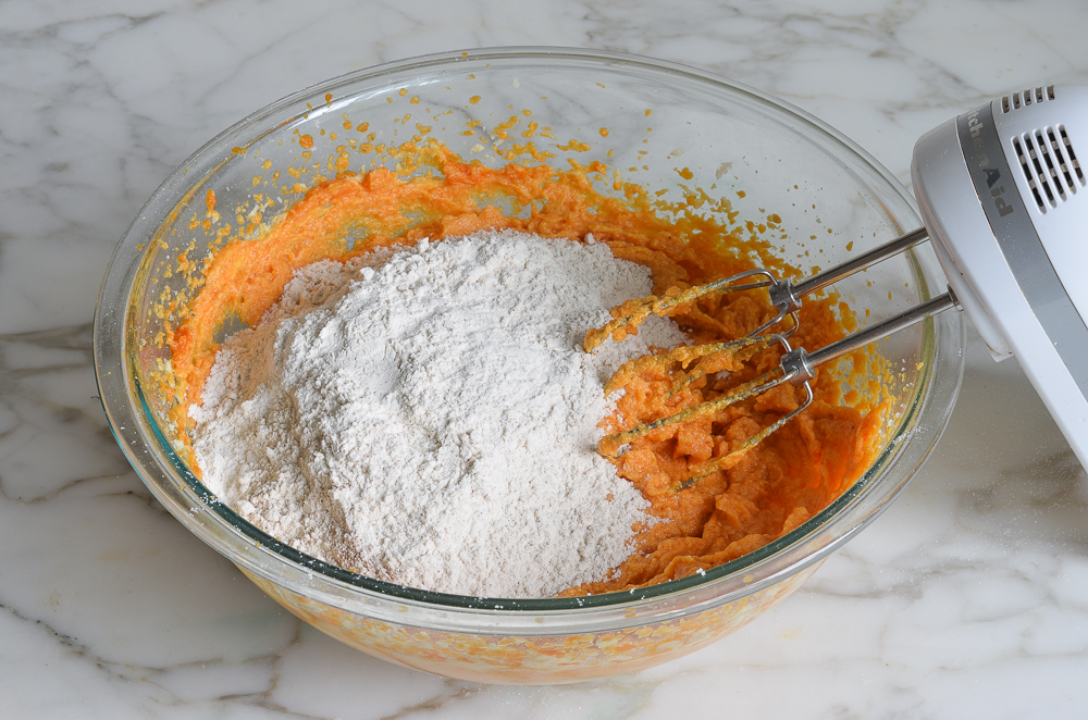Dry ingredients in a bowl with an orange-colored mixture.